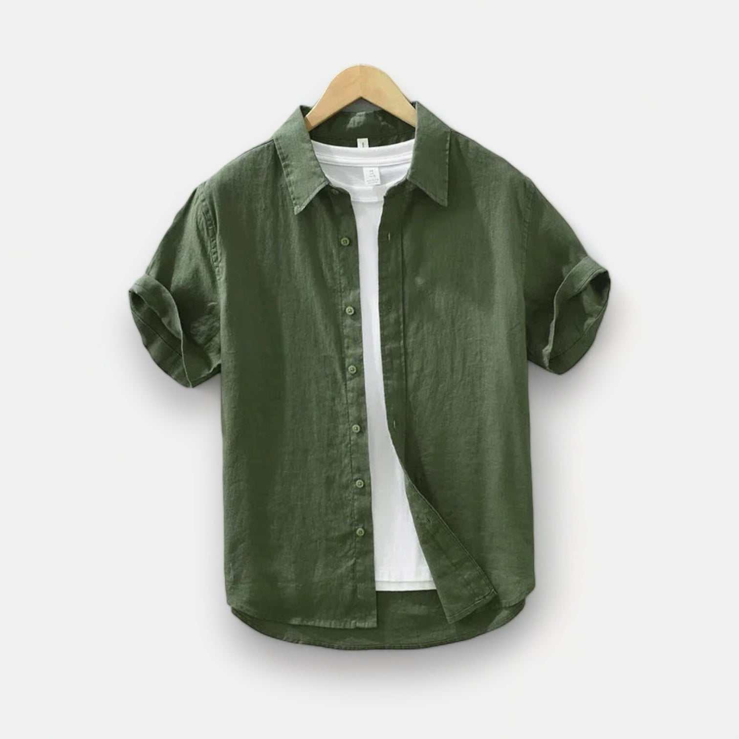 Green linen Antonios loose short sleeve summer shirt displayed on a hanger, perfect for spring/summer casual and elegant occasions.