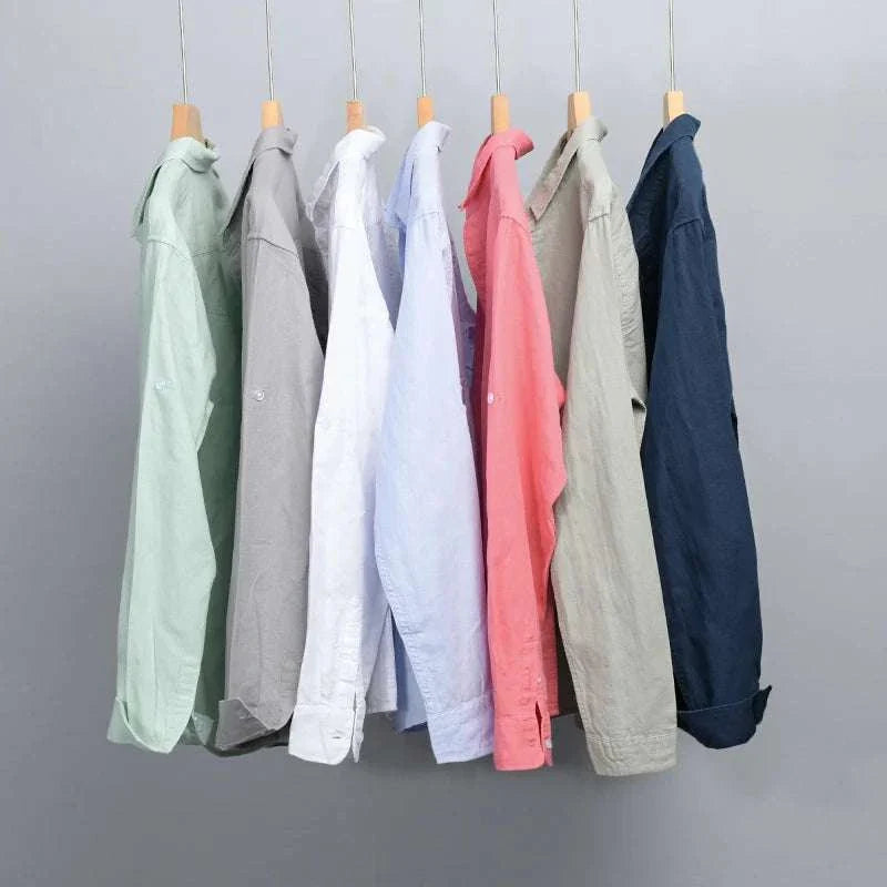 Colorful summer casual long-sleeve shirts in various solid colors hanging on a rack.