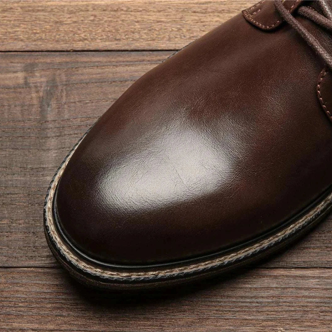 Retro British leather boots made of ecological leather and rubber on wooden floor.