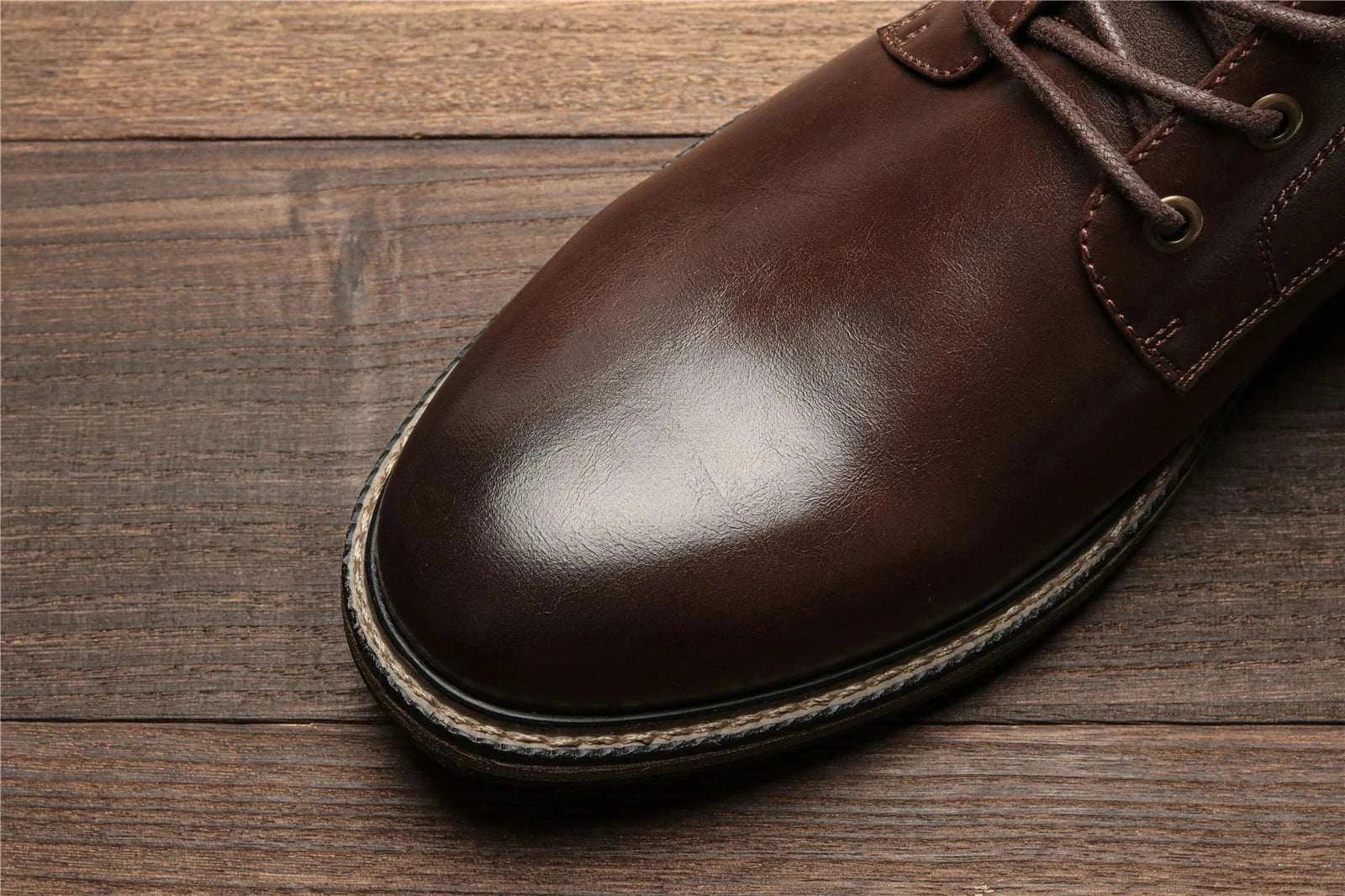 Retro British leather boots made of ecological leather and rubber on wooden floor.