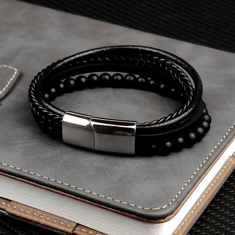Stainless steel stone bracelet on notebook, elegant and durable accessory.