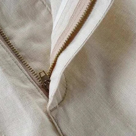 Close-up of beige linen casual pants with zipper detail.