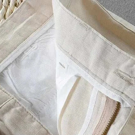 Close-up view of linen casual pants highlighting the button and zipper details.