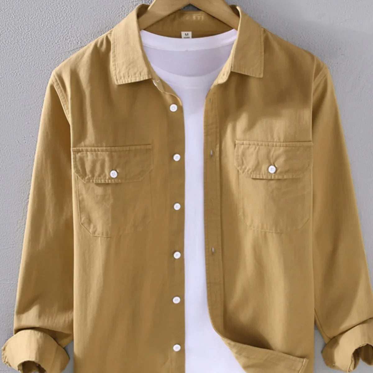 Men's long sleeve solid color casual outerwear on a hanger.