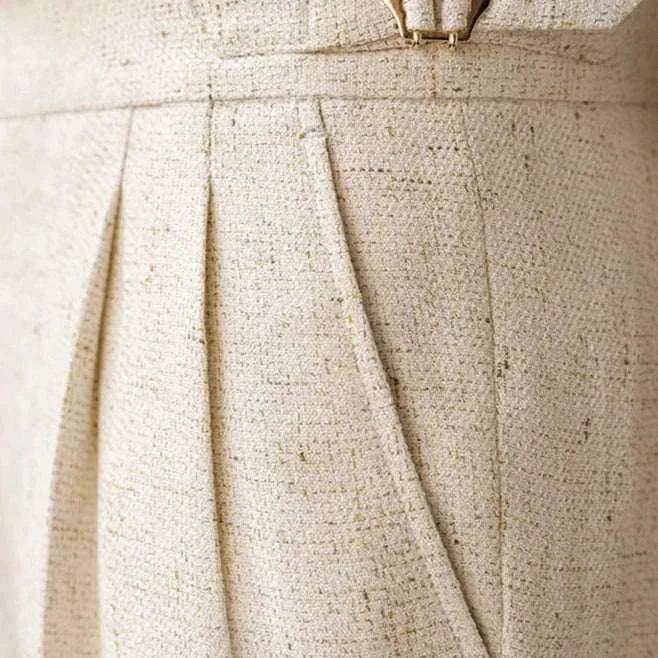 Paris high-waist design trousers in textured fabric with elegant pleats and buckle detail.