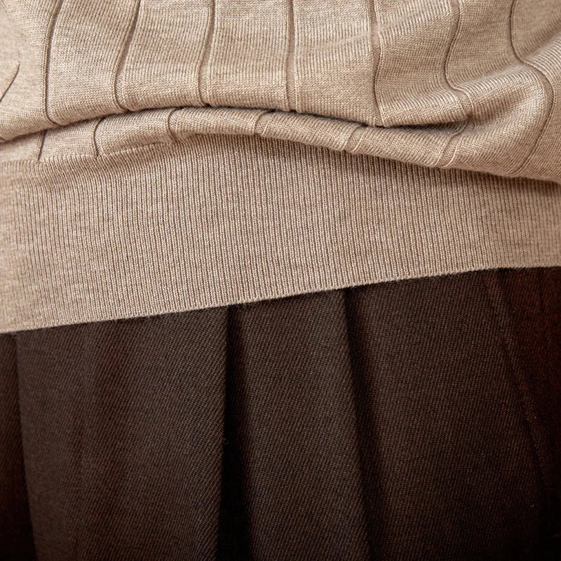 Close-up of a beige Woolblend sweater with a textured knit pattern.