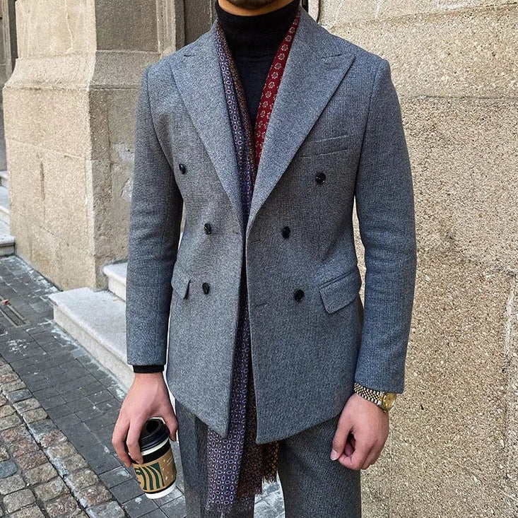 Office double breasted suit in gray, Italian style, worn by a man holding a coffee cup.