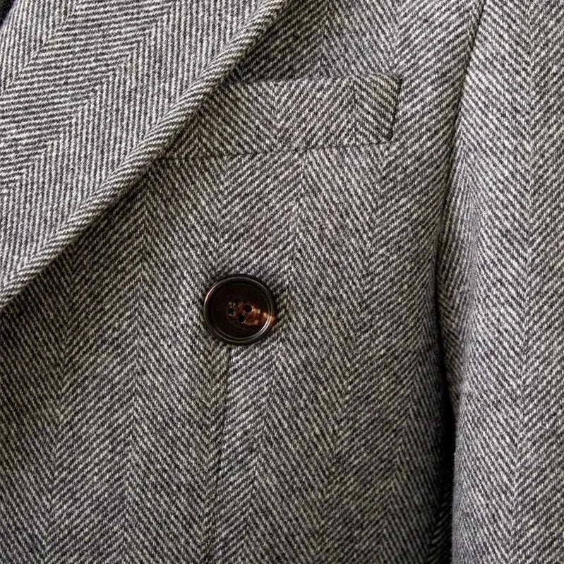 Close-up of a double-breasted wool coat in herringbone pattern for winter.