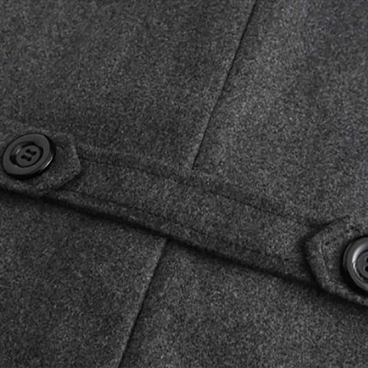 Close-up of buttoned strap detail on grey casual British long coat.