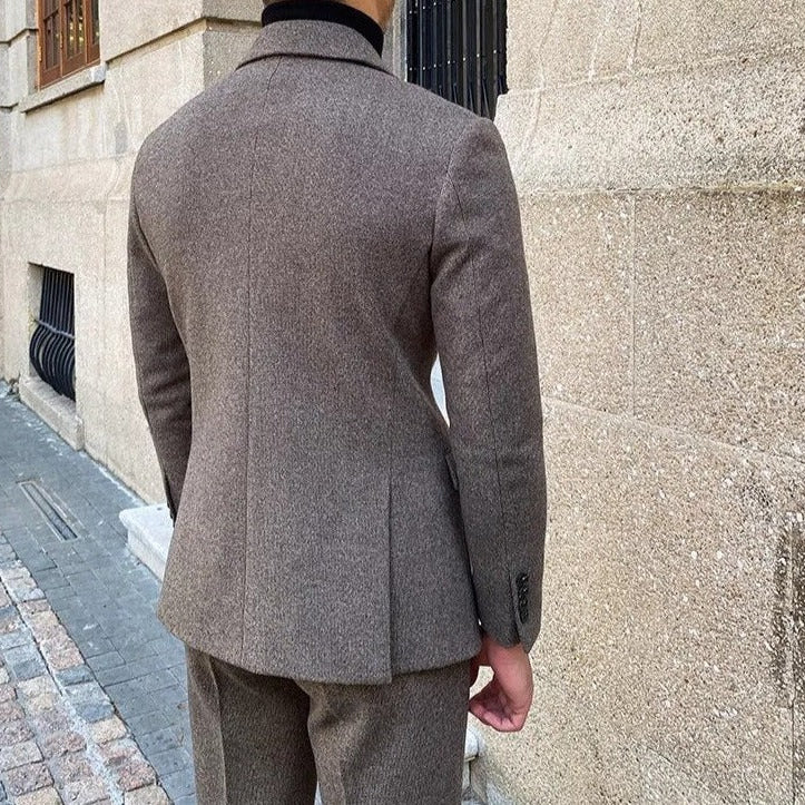Rear view of a man wearing an elegant office double-breasted suit in a sophisticated setting.