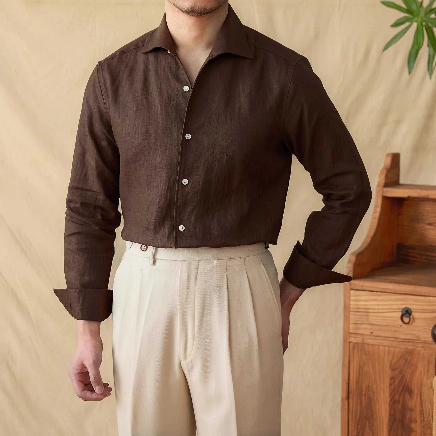 Linen elegant long sleeve shirt in dark fabric for men, styled casually in an indoor setting.