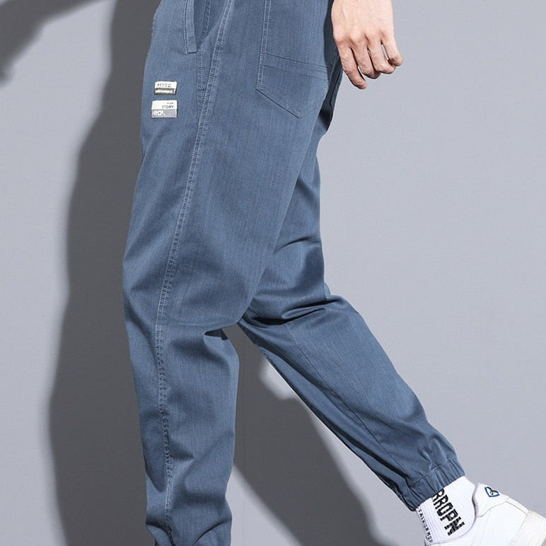 Vinny Loose Pants in blue, men's relaxed fit jogging pants with pockets, paired with casual white sneakers.