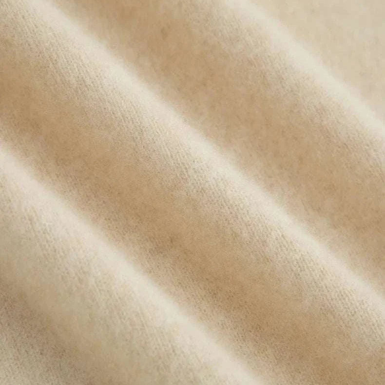 Close-up of beige wool fabric texture of a business turtleneck sweater.