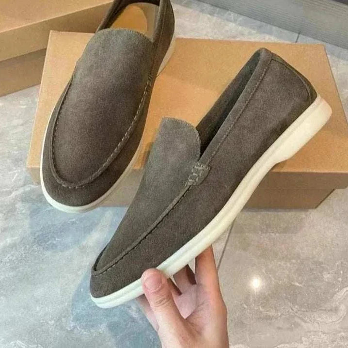 Suede elegant loafers made of sheep leather in gray, displayed on a box.