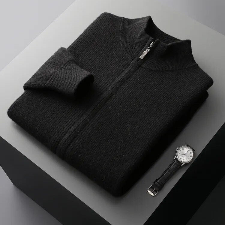 Folded black pure wool cardigan with a zip closure, displayed beside a watch on a minimalist surface.