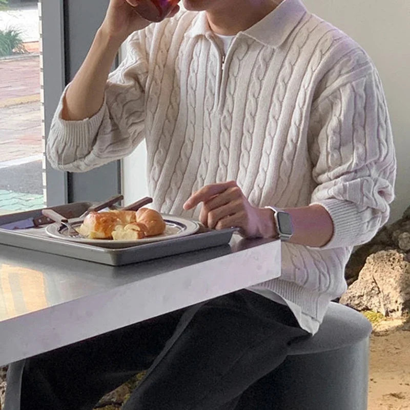 Man wearing a vintage design sweater at a cafe, showcasing casual elegance.