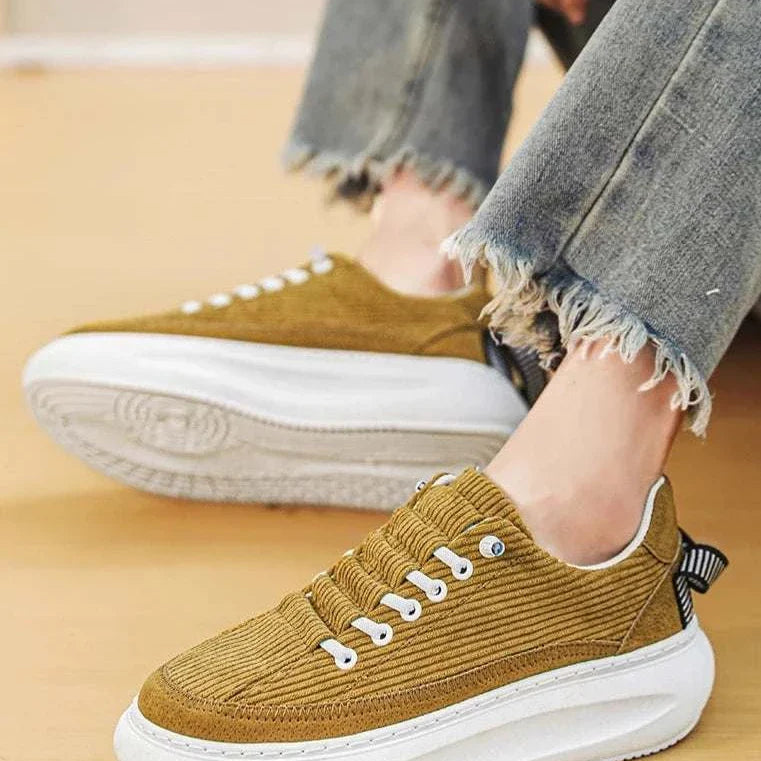 Men's breathable Cricket bulb shoes in yellow with frayed jeans.