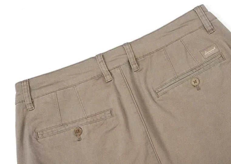 Back view of classic chino pants in beige with buttoned pockets and belt loops.