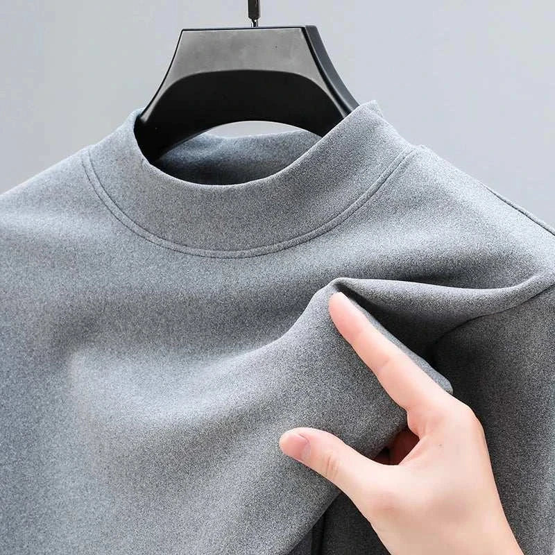 Classic turtleneck sweater in gray being held, showcasing soft cotton texture.