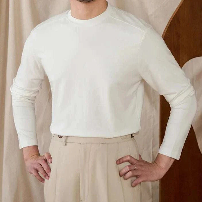Slim fit smart casual premium sweater in white, long sleeves, modeled with beige pants.