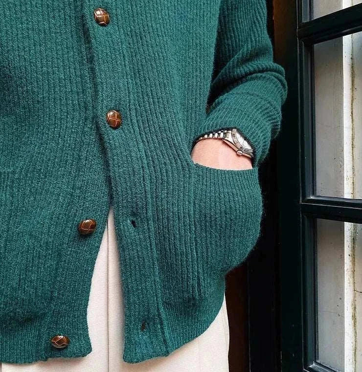 Oxford premium cardigan in dark green with buttons, showing pocket detail.