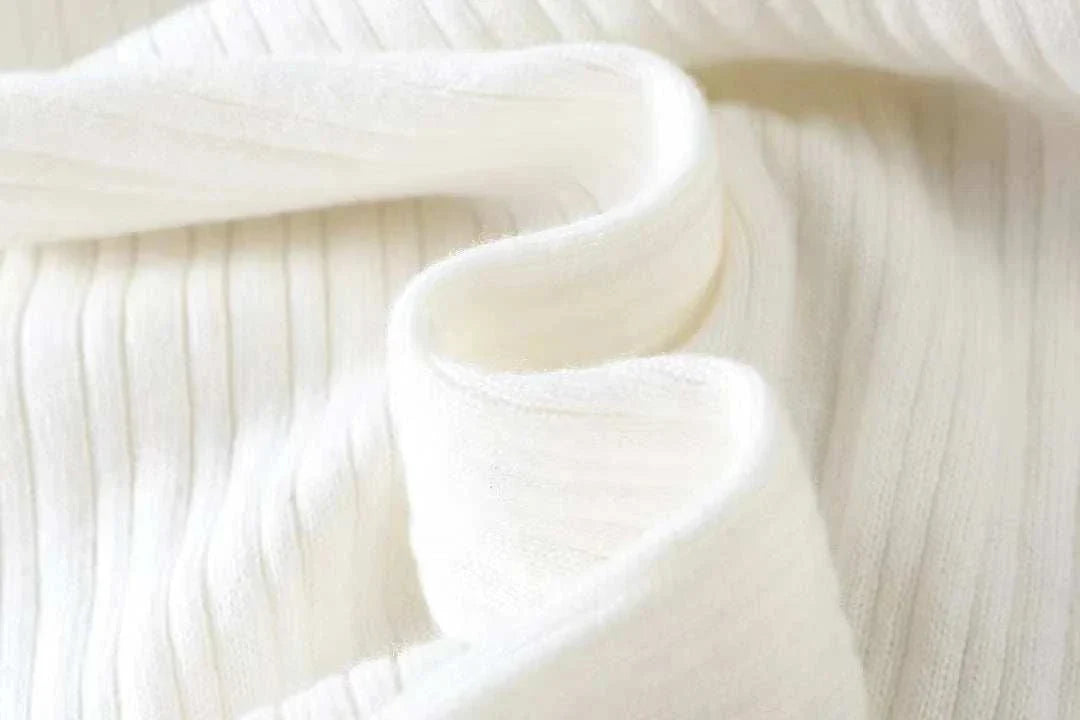 Close-up of Antonios striped jacquard knit sweater fabric in white.