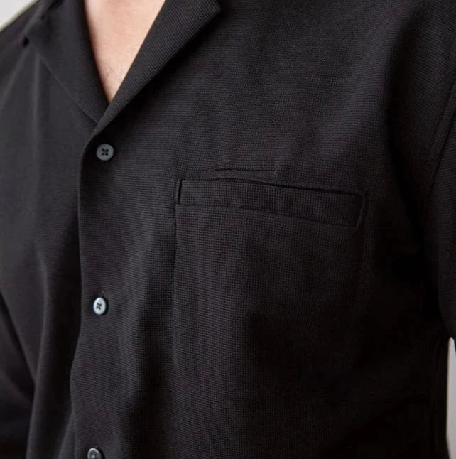 Turn-down collar shirt in black with a front pocket and buttons for a smart casual look.