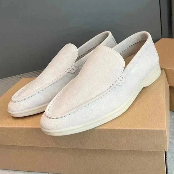 Suede elegant loafers in soft sheep leather on a shoebox.