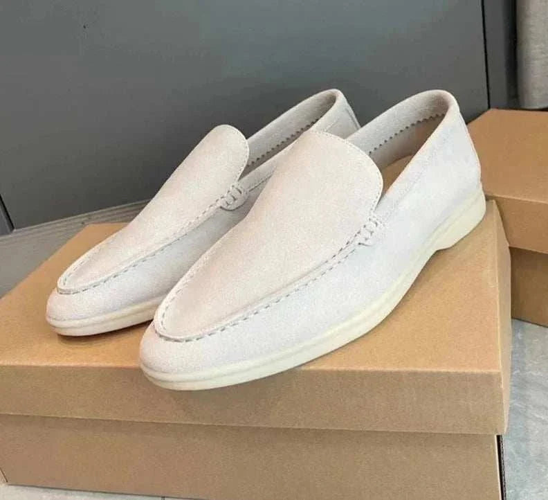 Suede elegant loafers in soft sheep leather on a shoebox.