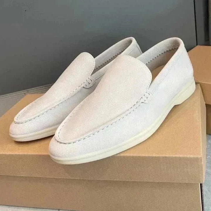 Suede elegant loafers made from soft sheep leather displayed on top of a box.