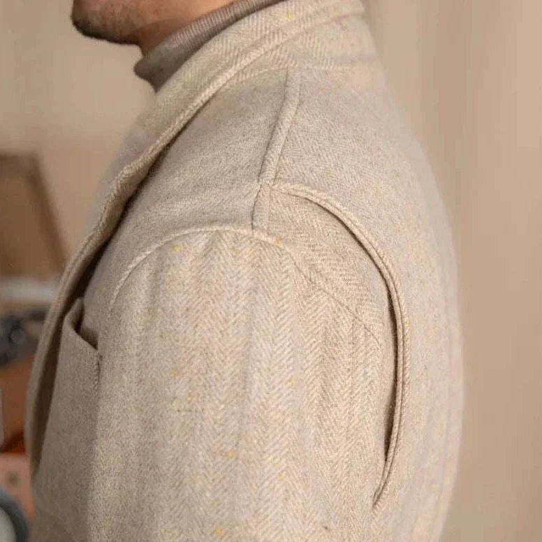 Close-up of a premium British winter jacket showcasing wool and cotton blend fabric in a neutral color.