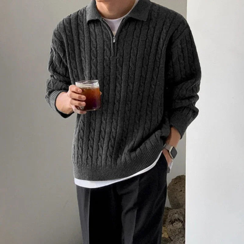 Man wearing a dark grey vintage design sweater with solid pattern.