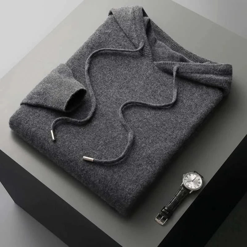 Gray wool cold season sweater for men on a dark surface next to a wristwatch.