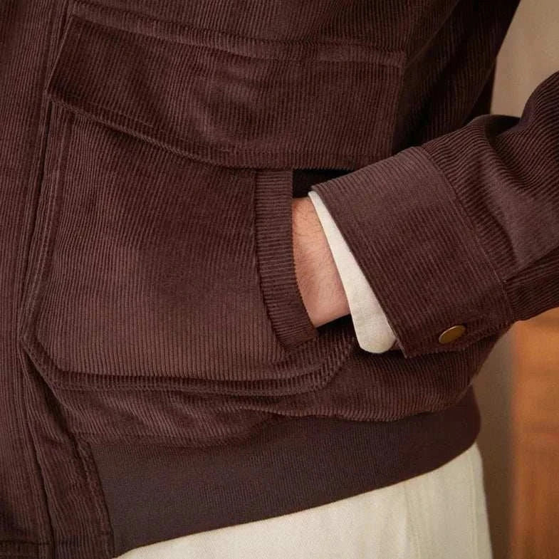 Close-up of a pure cotton bomber jacket in brown with a hand in the pocket.