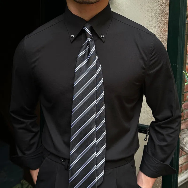 Man wearing Antonios Oxford Shirt in black with long sleeves and striped tie, suitable for smart casual outfits.