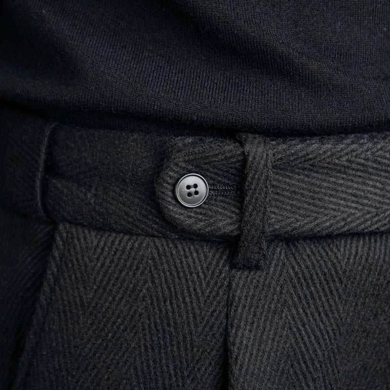 Close-up of black winter wool Italian trousers with button detail.