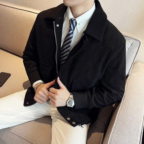 Men's corduroy casual jacket in black, worn with a white shirt and tie.