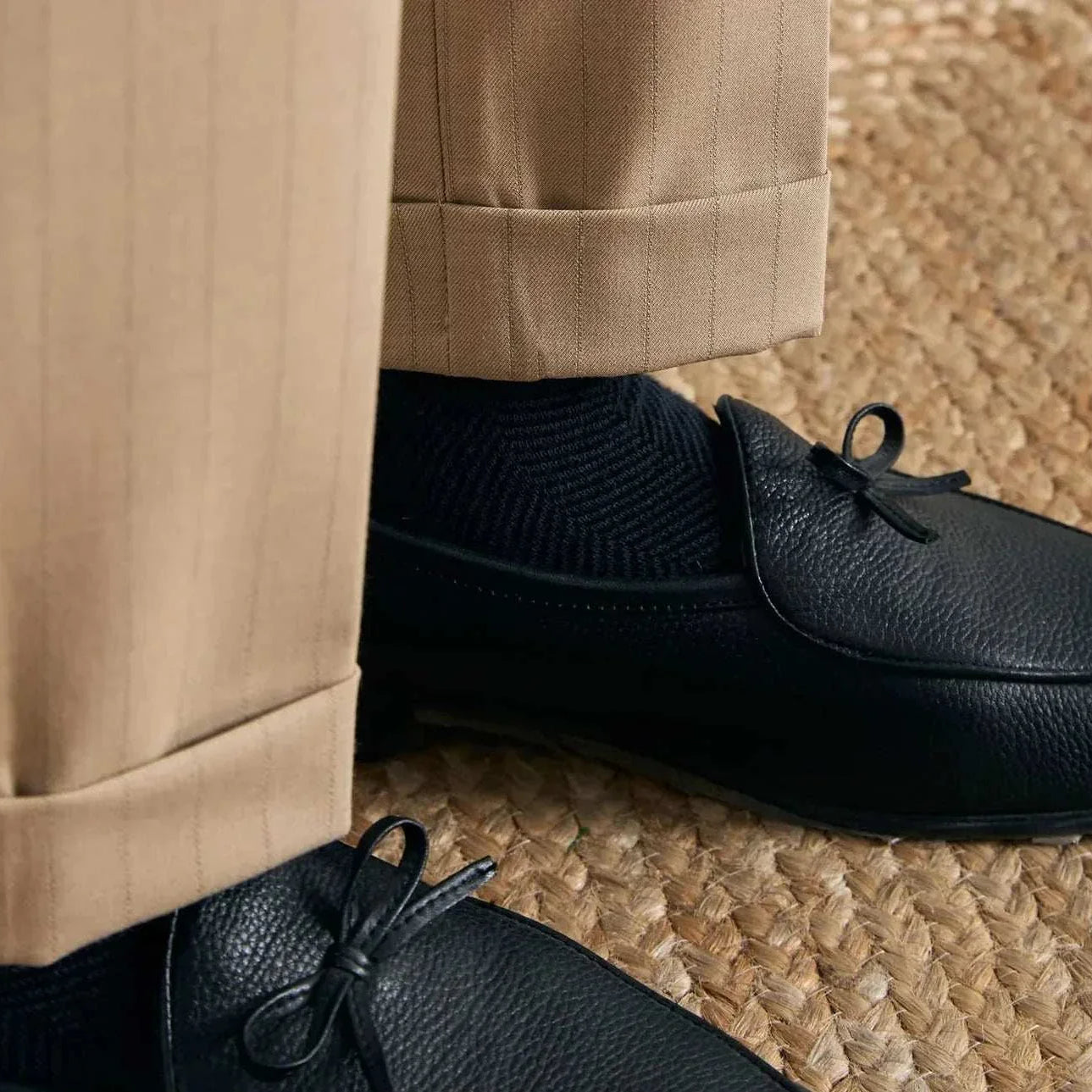 Office outfit high waist trousers paired with black shoes on a textured mat.