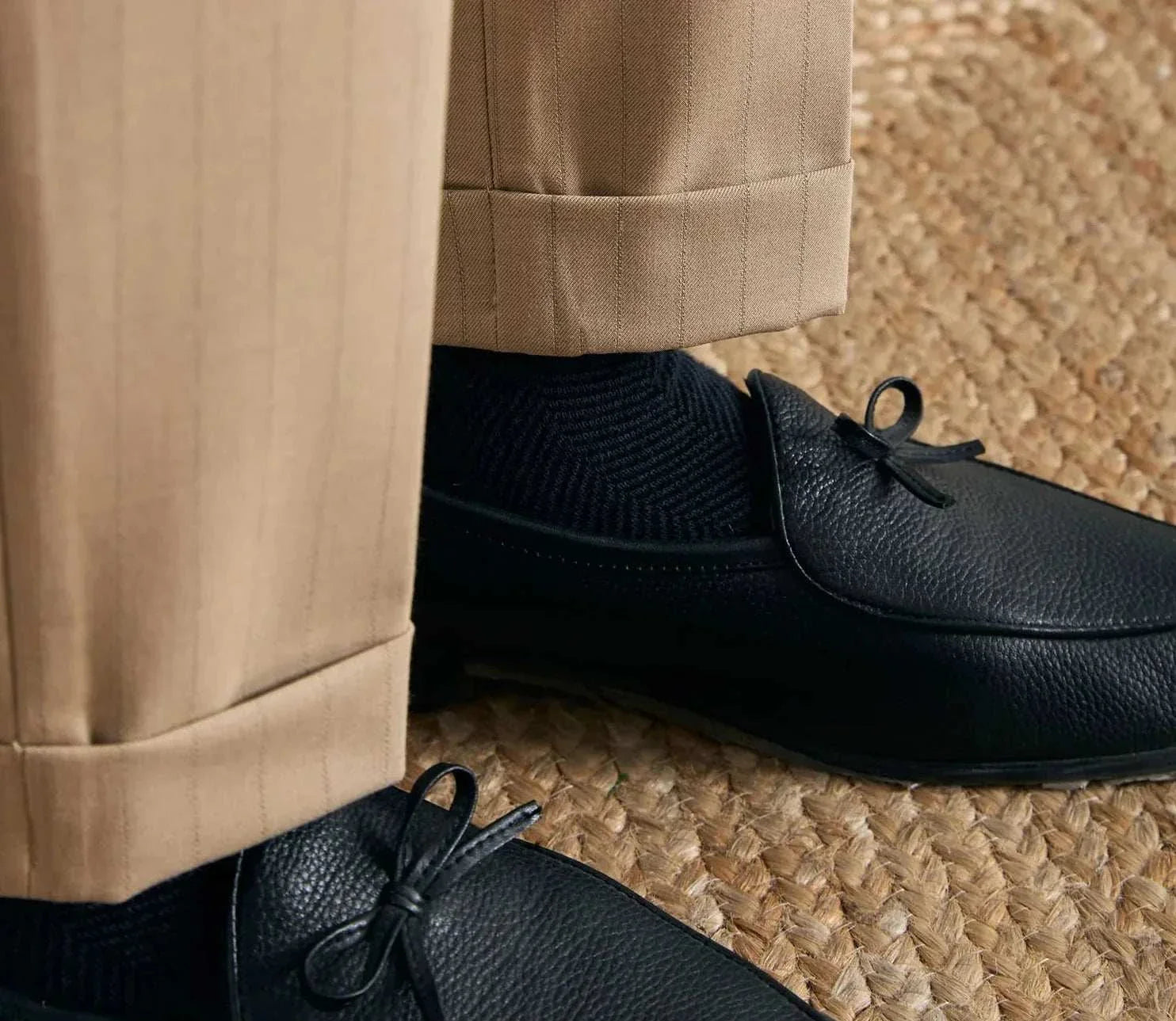 Office outfit high waist trousers paired with black shoes on a textured mat.