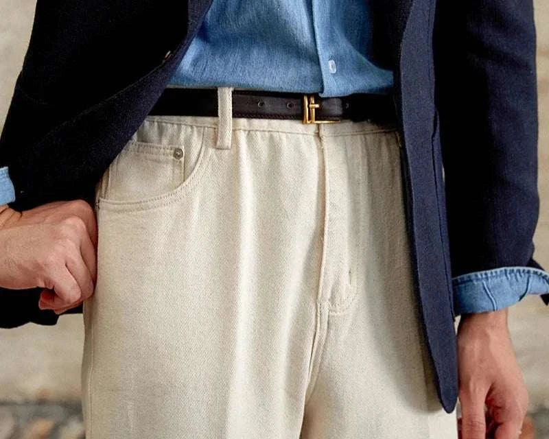 British pure cotton old money pants in cream color, worn with a blue shirt and black belt.