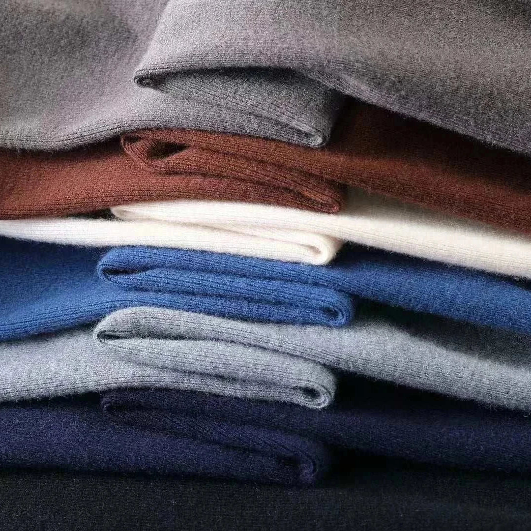 Stack of folded wool sweaters in various colors.