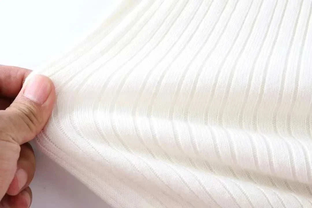 Close-up of Antonios striped jacquard knit sweater fabric in white, showcasing its texture and knit pattern.