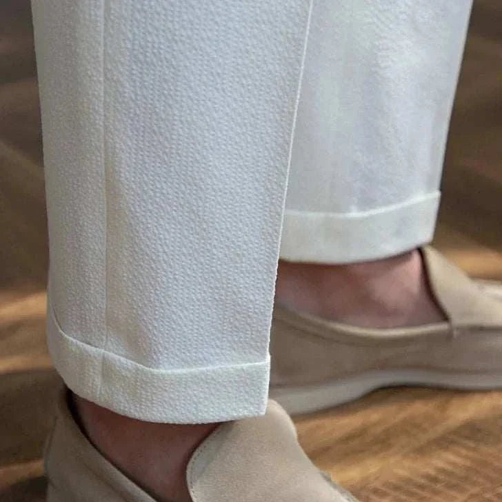 Italian design office high-waist trousers in a solid pattern, worn with beige shoes.