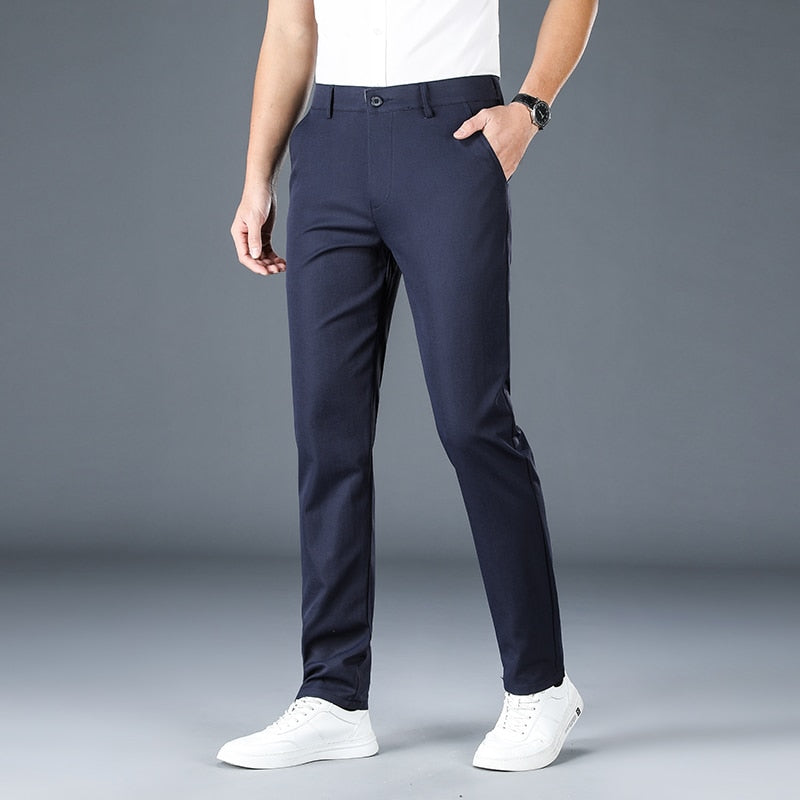 Antonios Stretch Pants in dark blue, full-length casual men's trousers, styled with white sneakers.