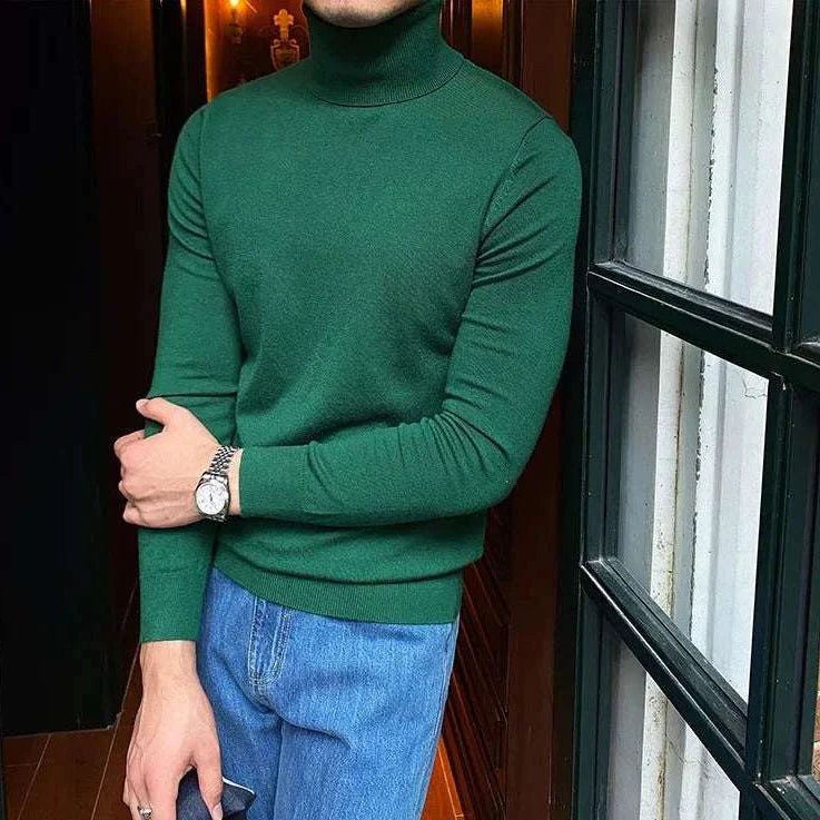 Antonios business turtleneck sweater in green paired with blue jeans.