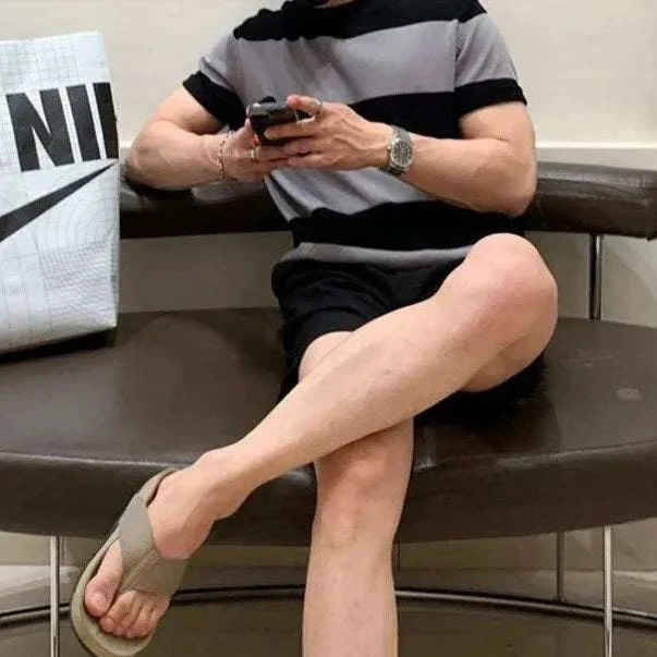 Antonios o-neck striped summer t-shirt in casual setting, worn by a person seated on a brown bench with a shopping bag nearby.