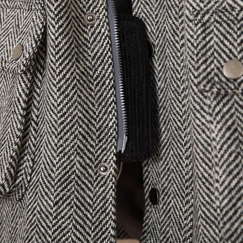 Close-up of herringbone patterned wool heavy vintage coat showing buttons and zipper.