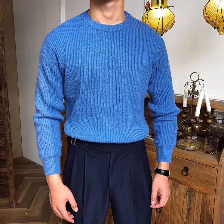 Antonios solid round neck knit sweater in blue, made of high-quality standard wool, worn by a male model.