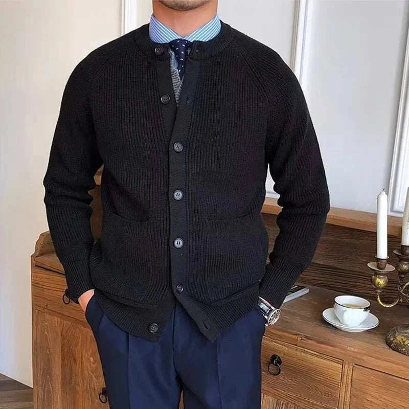 Man wearing Antonios winter cardigan, black buttoned sweater over blue shirt and tie, adding warmth and style.