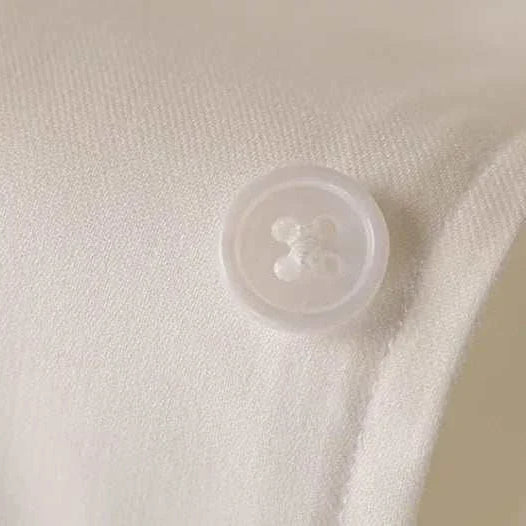 Close-up of Antonios washed tuxedo shirt button detail, stylish office wear.